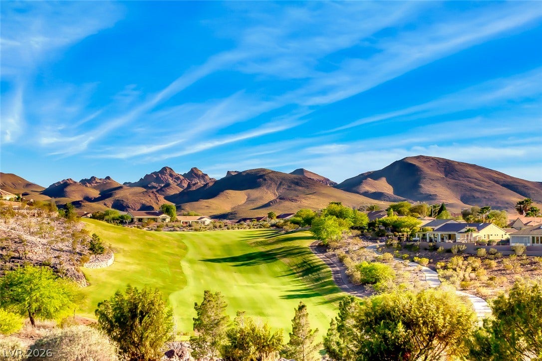 2601 Arimo Drive, Henderson, NV 89052 Dramatic mountain ranges frame the verdant golf course winding past neighboring residential estates.