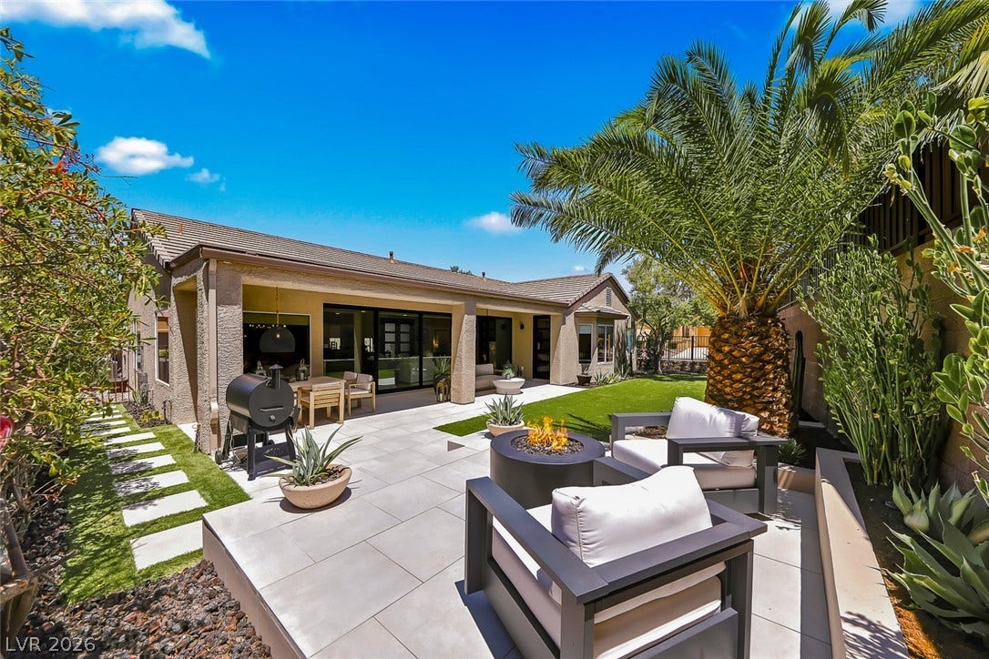 2601 Arimo Drive, Henderson, NV 89052 A spacious stone terrace wraps around the back of the home, framed by lush tropical landscaping.