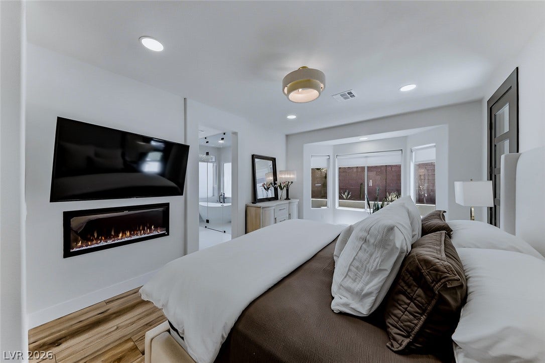 2601 Arimo Drive, Henderson, NV 89052 An elegant master suite showcases a linear electric fireplace and warm wood-look flooring.