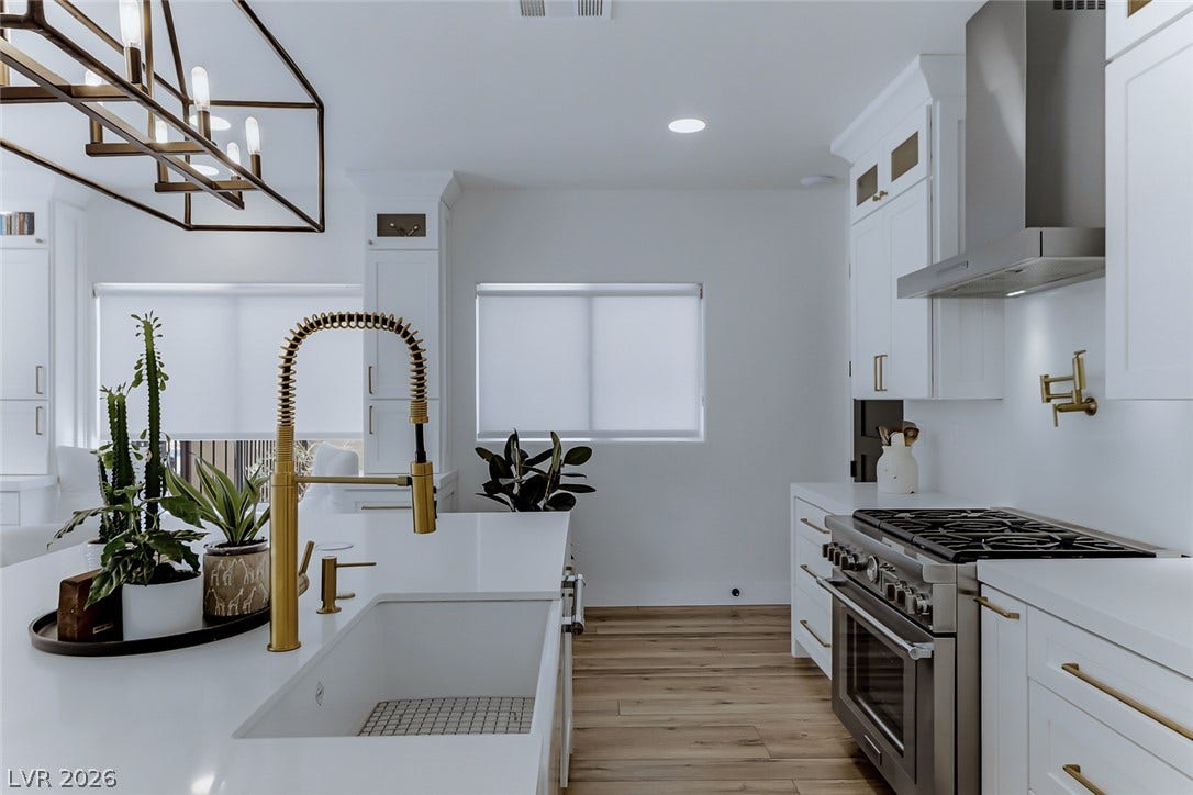 2601 Arimo Drive, Henderson, NV 89052 Elegant hardwood flooring anchors a culinary space featuring a professional-grade range and pristine solid surfaces.
