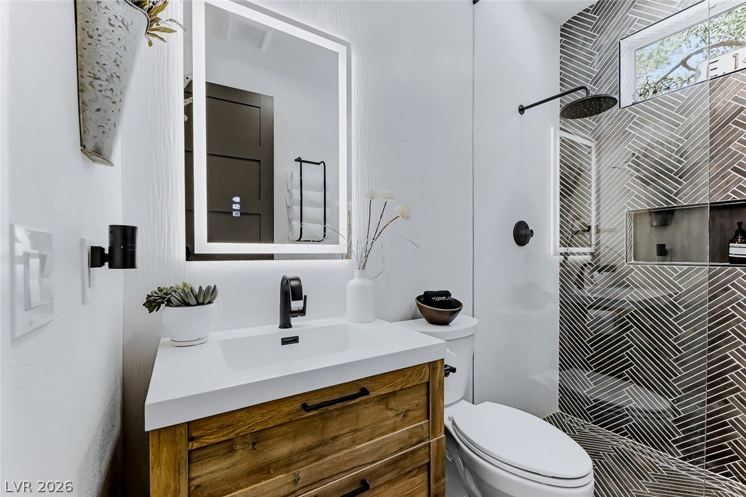 2601 Arimo Drive, Henderson, NV 89052 An updated bathroom features a custom vanity and a modern walk-in shower with textured tilework.