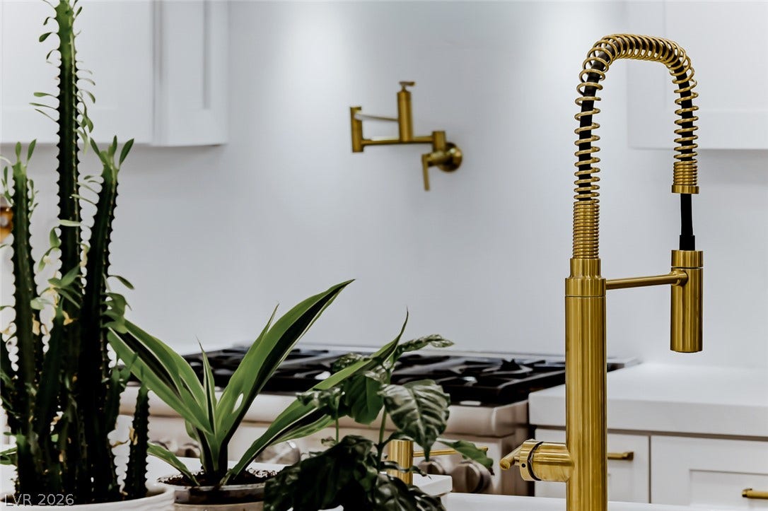 2601 Arimo Drive, Henderson, NV 89052 Gleaming brass fixtures elevate this modern culinary space featuring clean lines and solid stone countertops.