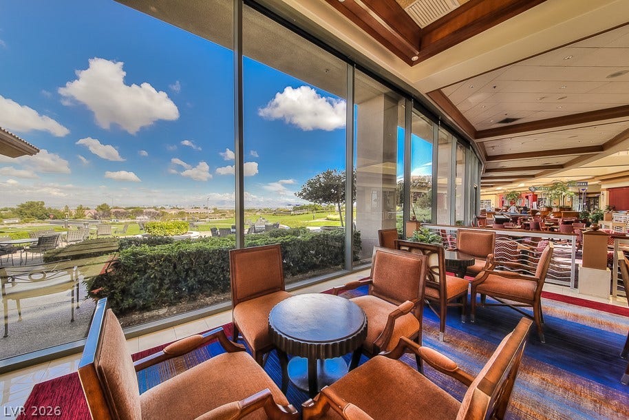2601 Arimo Drive, Henderson, NV 89052 Floor-to-ceiling glass walls frame serene outdoor views beneath custom wood-trimmed ceilings.