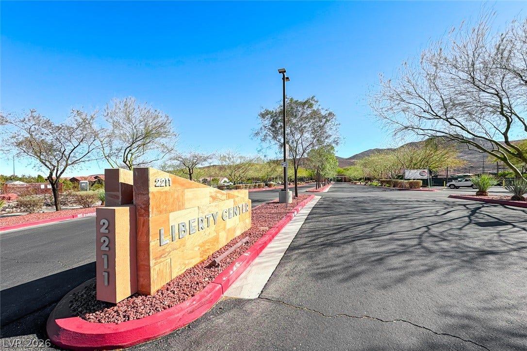 2601 Arimo Drive, Henderson, NV 89052 An inviting stone monument sign marks the paved entry drive under clear desert skies.