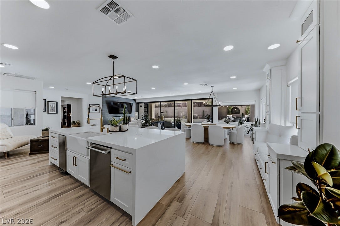 2601 Arimo Drive, Henderson, NV 89052 An open floorplan connects the modern kitchen and dining areas over sleek wood flooring.