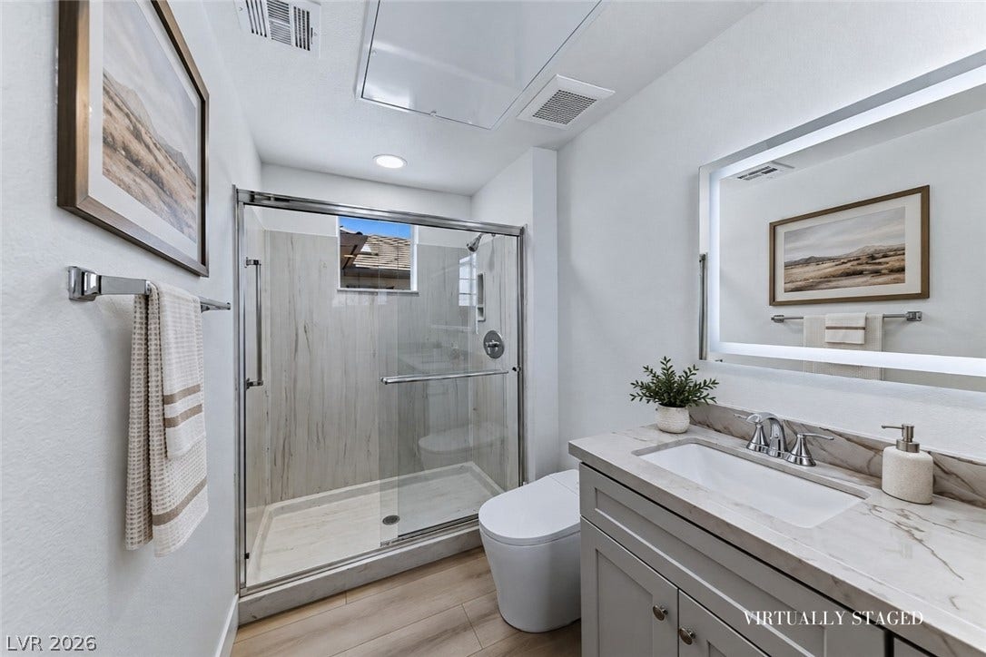 2601 Arimo Drive, Henderson, NV 89052 Clean lines and stone counters highlight this modern bathroom with a glass-enclosed shower.