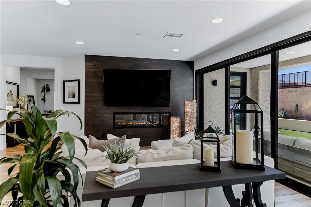 2601 Arimo Drive, Henderson, NV 89052 A modern fireplace wall and sliding glass doors highlight this comfortable living area.