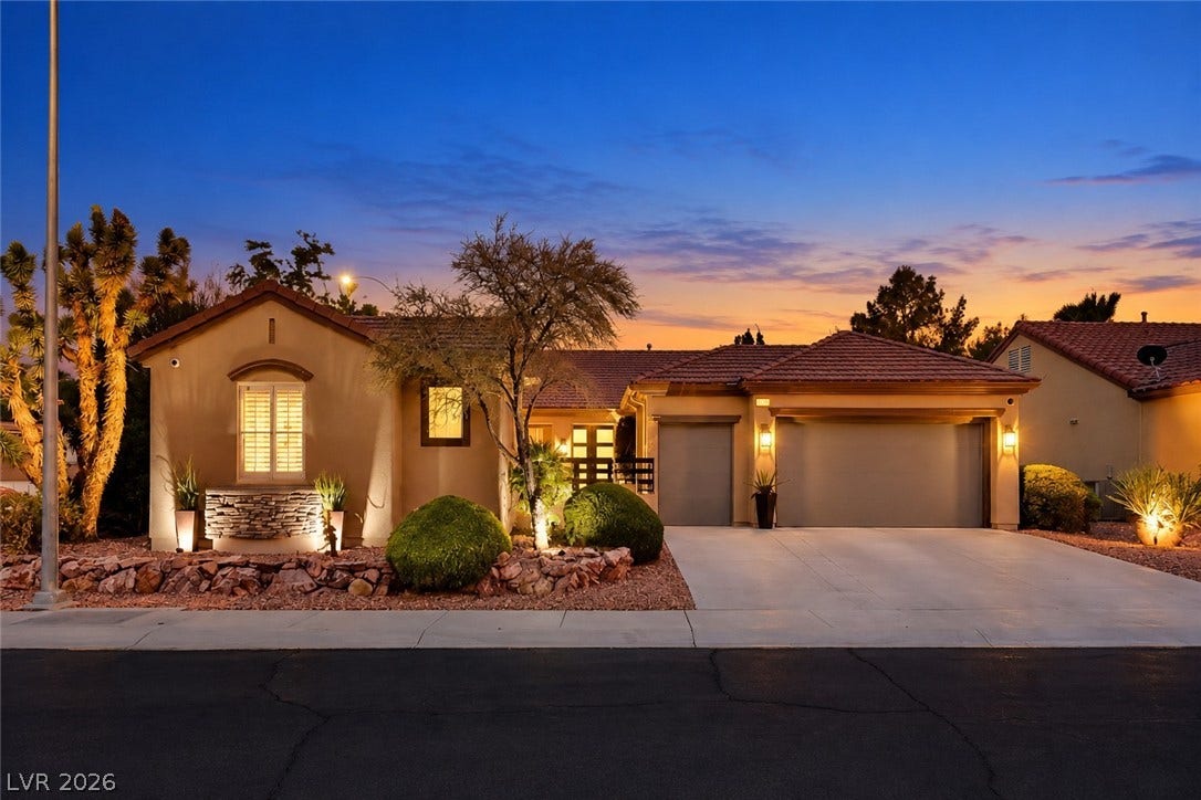 2601 Arimo Drive, Henderson, NV 89052 Warm exterior lighting accents this modern desert home under a beautiful sunset sky.