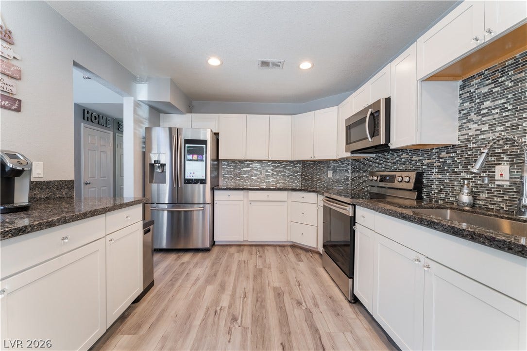 6250 W Flamingo Road, #37, Las Vegas, NV 89103 A well-appointed kitchen features stainless steel appliances, granite countertops, and light wood-look flooring.