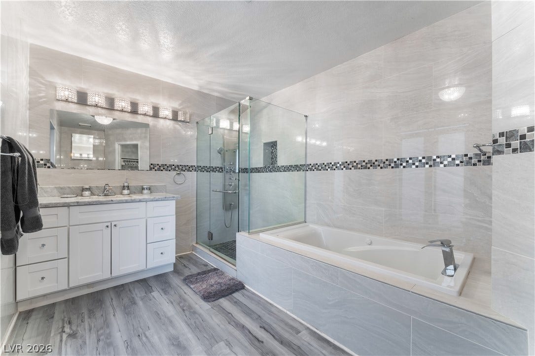 6250 W Flamingo Road, #37, Las Vegas, NV 89103 Luxurious bathroom features a glass-enclosed shower, a deep soaking tub, and stylish dual vanities.