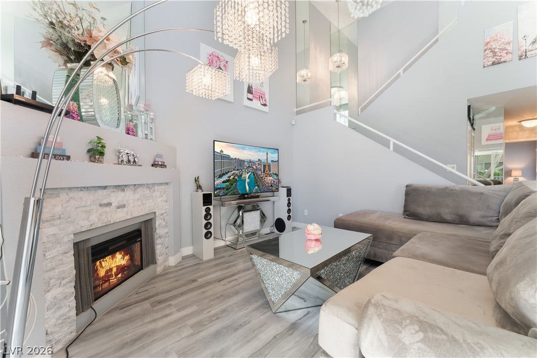 6250 W Flamingo Road, #37, Las Vegas, NV 89103 A well-lit living area showcases a sleek fireplace and elegant chandelier lighting.