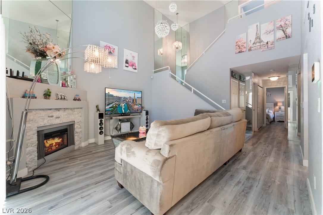 6250 W Flamingo Road, #37, Las Vegas, NV 89103 Elegant living space features high ceilings, a cozy fireplace, and rich wood flooring.