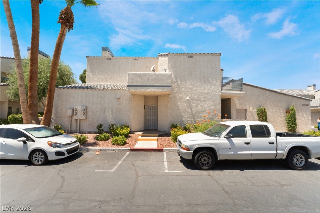 6250 W Flamingo Road, #37, Las Vegas, NV 89103 A cream-colored stucco exterior with a distinctive entry and mature landscaping presents a welcoming facade.