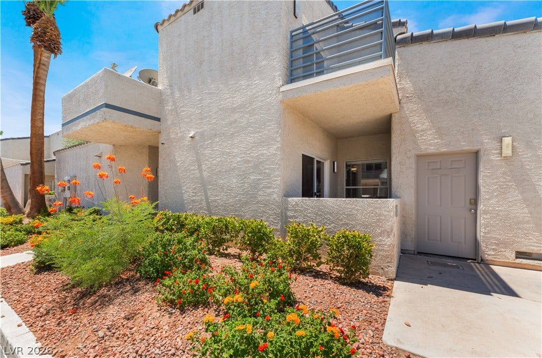 6250 W Flamingo Road, #37, Las Vegas, NV 89103 A well-maintained multi-level building with vibrant landscaping and private balconies.