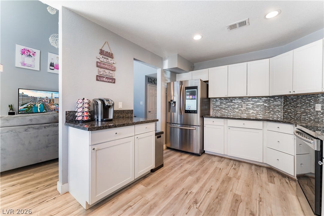 6250 W Flamingo Road, #37, Las Vegas, NV 89103 Well-appointed kitchen features granite counters, stainless steel appliances, and sleek hardwood flooring.