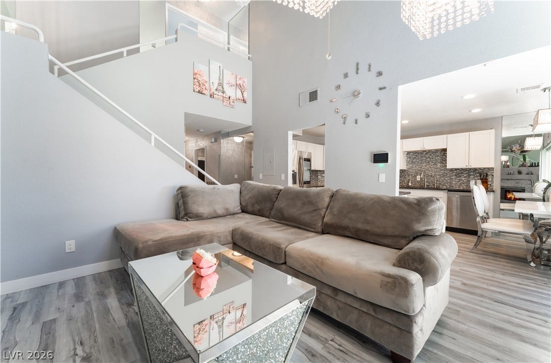 6250 W Flamingo Road, #37, Las Vegas, NV 89103 Two-story ceilings and sleek flooring complement this open-concept living area, seamlessly connecting to the kitchen.