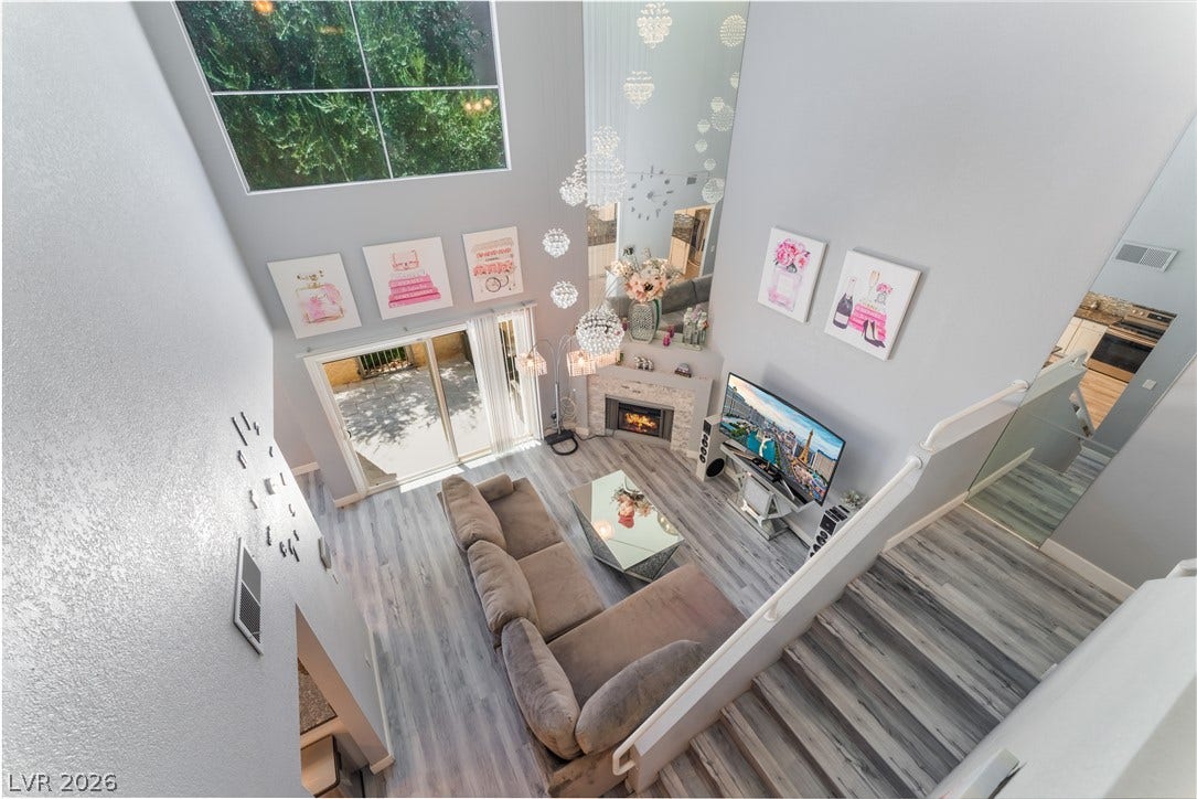 6250 W Flamingo Road, #37, Las Vegas, NV 89103 A striking living space showcases a corner fireplace, soaring ceilings, and a clear view of the outside.