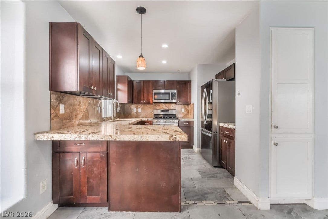 Kitchen featuring stainless steel appliances, a peninsula, backsplash, dark brown cabinets, and recessed lighting