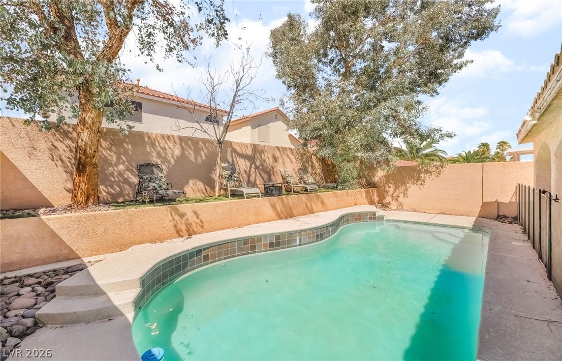 View of swimming pool with a patio and a fenced backyard