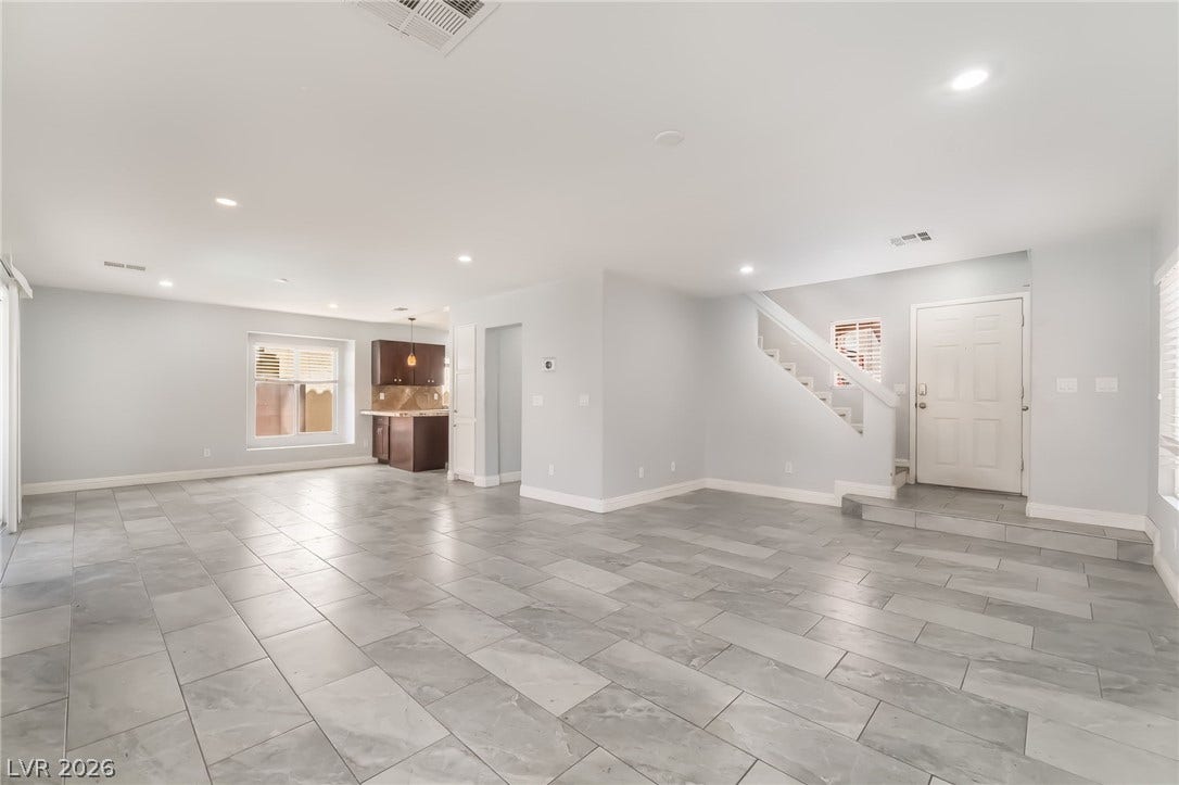 Unfurnished living room with stairs and recessed lighting