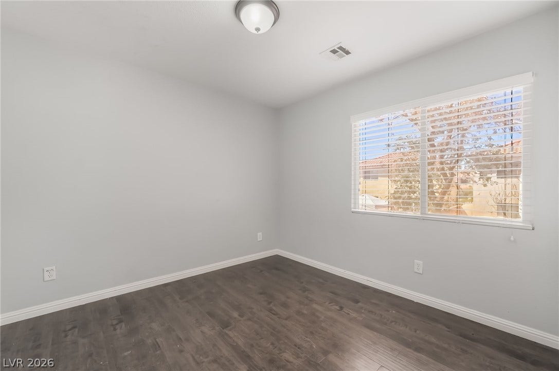 Unfurnished room with dark wood-style floors and baseboards