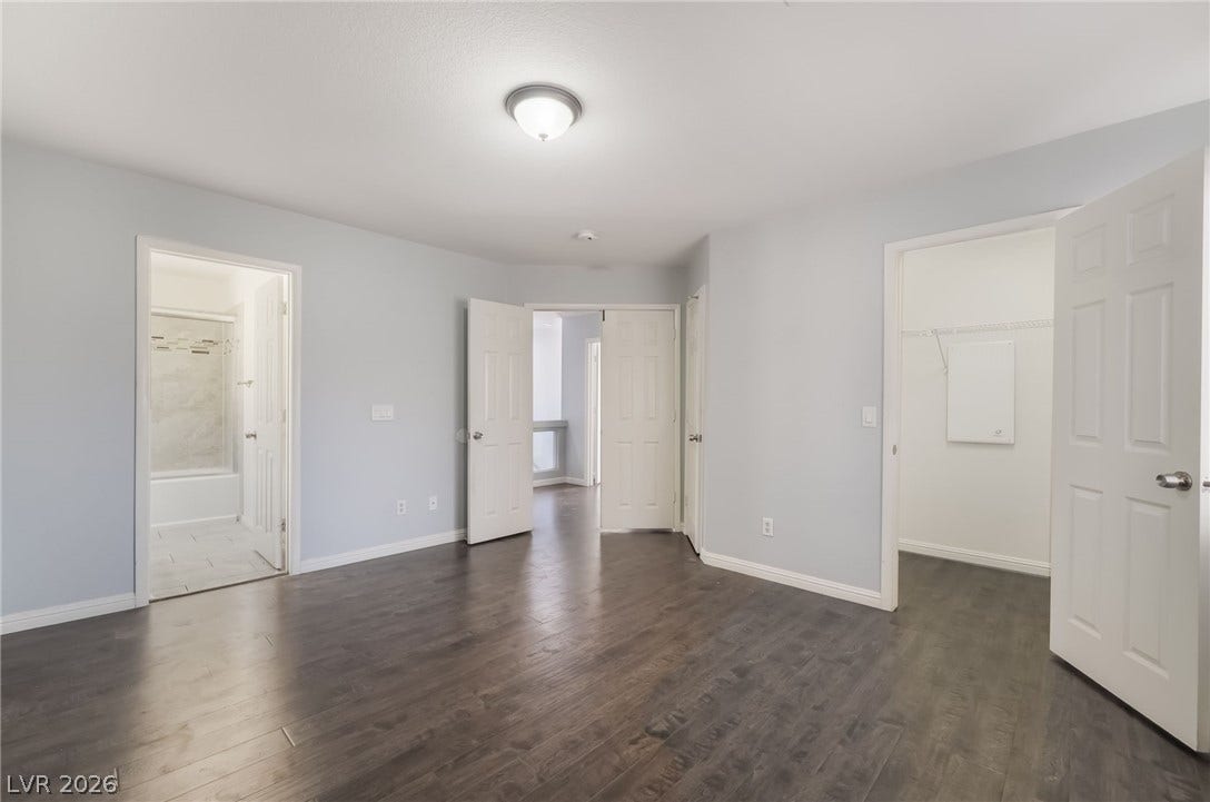 Unfurnished bedroom with dark wood finished floors and a spacious closet