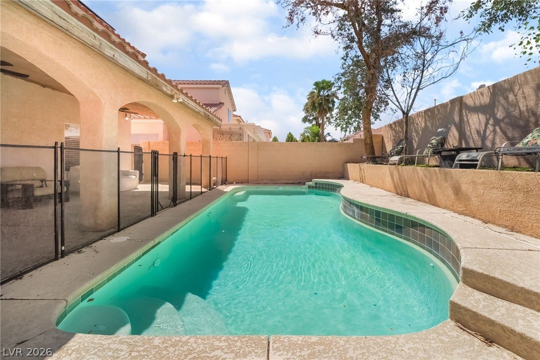 View of swimming pool with a patio area and a fenced backyard