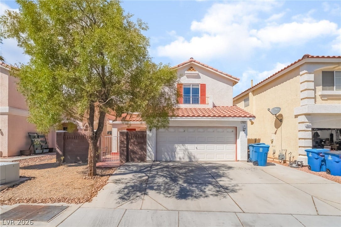 Mediterranean / spanish-style house featuring a tiled roof, stucco siding, an attached garage, driveway, and a gate