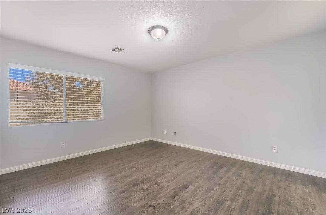 Empty room with baseboards and dark wood-style floors