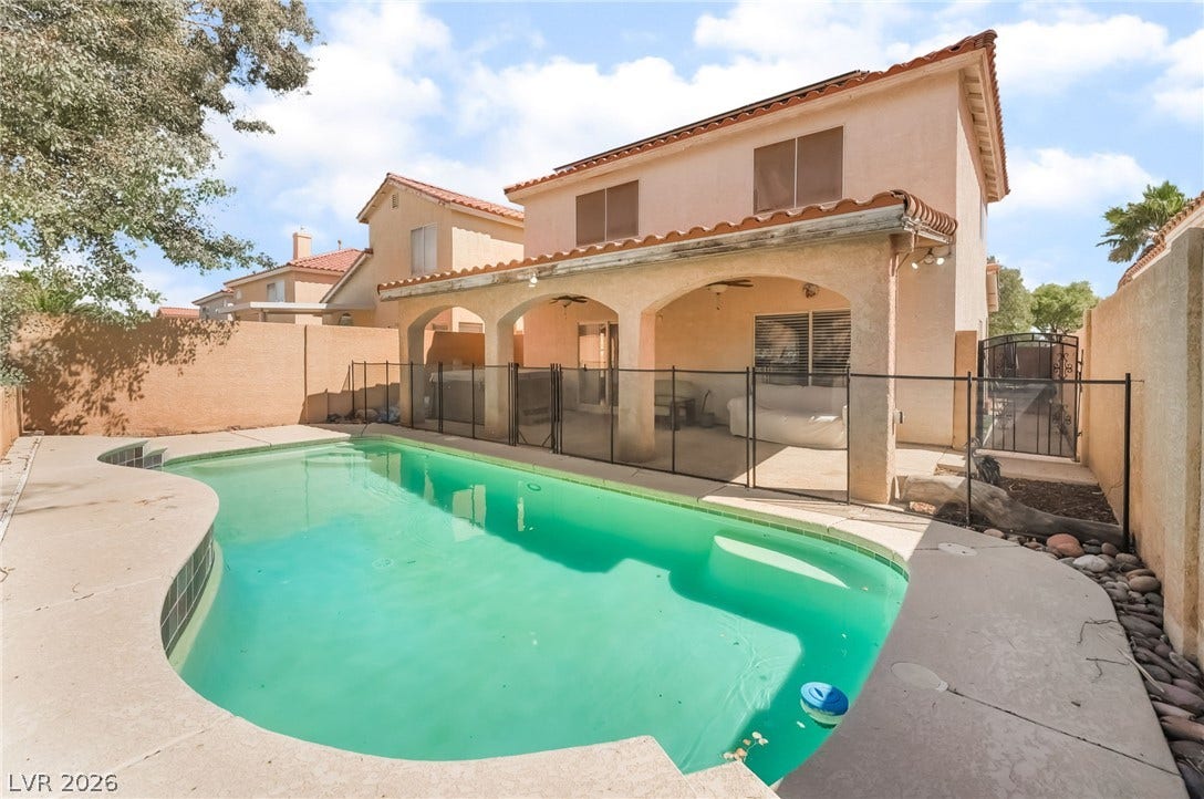 Rear view of property with a patio, a fenced backyard, a gate, and a tile roof