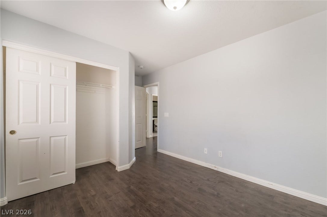 Unfurnished bedroom featuring dark wood finished floors and a closet