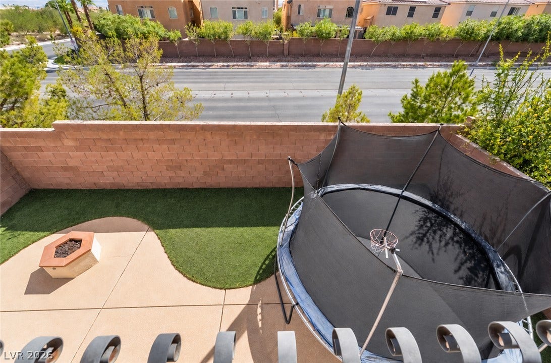 6771 Bravura Court, Las Vegas, NV 89139 An elevated perspective overlooks a landscaped backyard enclosed by block fencing.