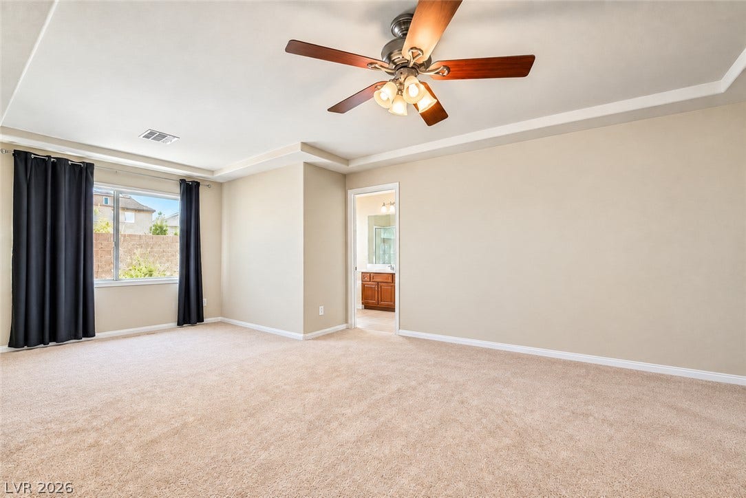 6771 Bravura Court, Las Vegas, NV 89139 A tray ceiling highlights the open architecture of this comfortable primary bedroom suite.