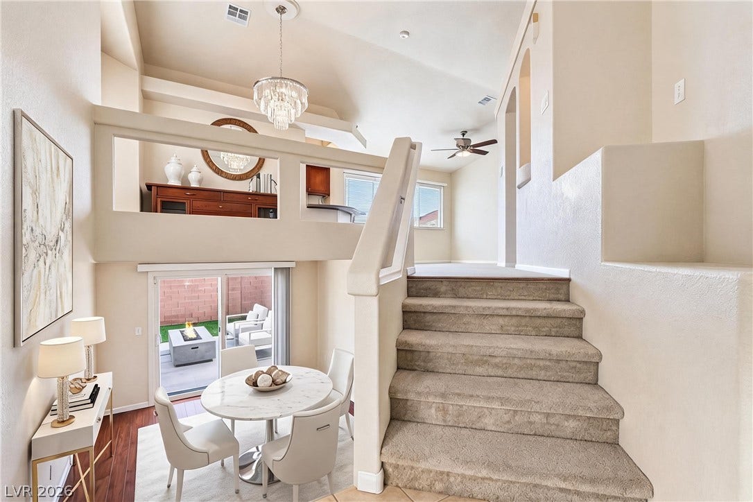 6771 Bravura Court, Las Vegas, NV 89139 Multi-level living spaces connect seamlessly, highlighted by towering ceilings and a carpeted staircase.