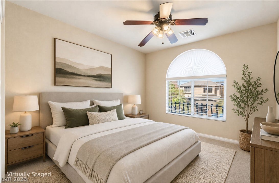 6771 Bravura Court, Las Vegas, NV 89139 A classic arched window filters light across the neutral walls and soft carpet flooring.
