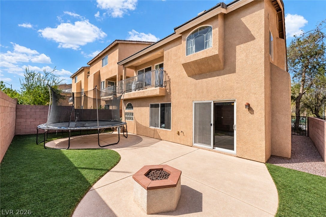 6771 Bravura Court, Las Vegas, NV 89139 An inviting backyard patio features concrete surfacing, a built-in fire pit, and durable stucco walls.