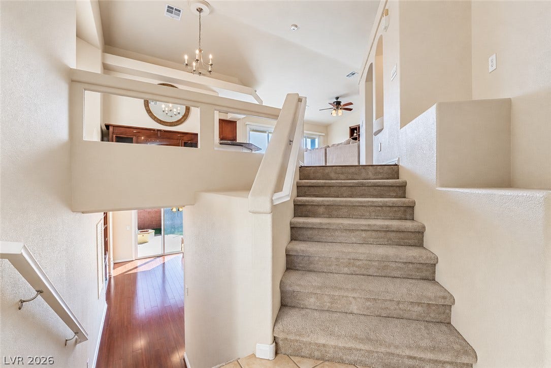 6771 Bravura Court, Las Vegas, NV 89139 Carpeted stairs ascend to an open-concept upper level with soaring vaulted ceilings.