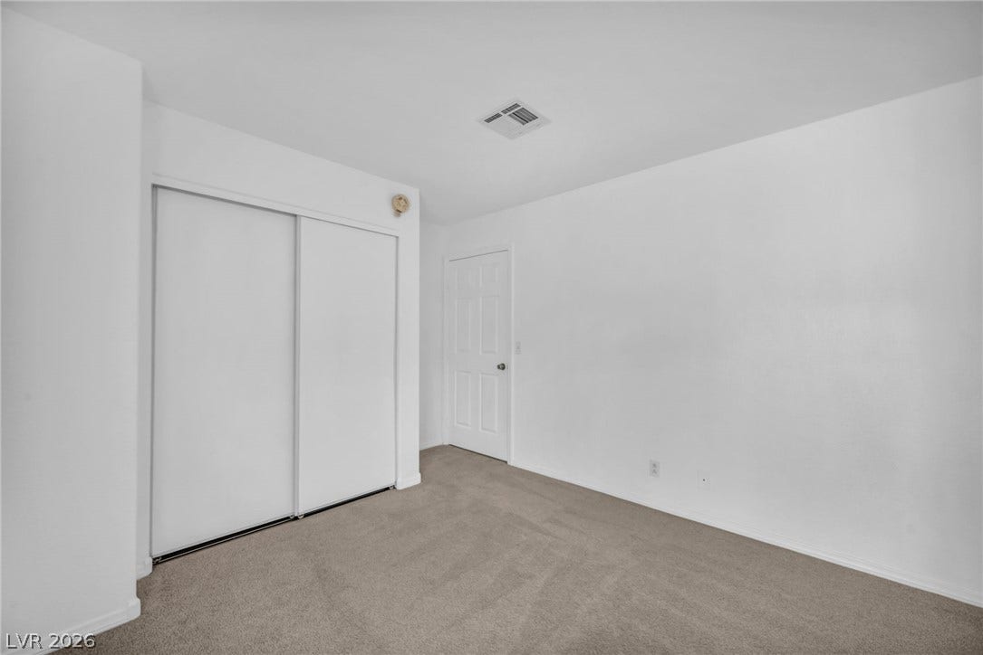 3613 Shawn Reynolds Court, #104, Las Vegas, NV 89129 Bedroom 2 - Plush neutral carpeting and sliding closet doors define this versatile secondary bedroom space.