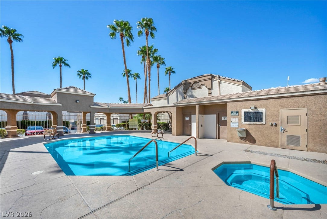 3613 Shawn Reynolds Court, #104, Las Vegas, NV 89129 A refreshing swimming pool and hot tub sit framed by towering palm trees.