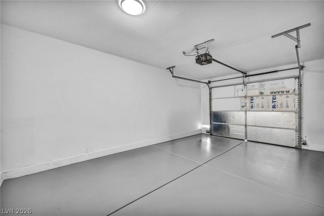 3613 Shawn Reynolds Court, #104, Las Vegas, NV 89129 Smooth concrete floors and a modern automatic door define this clean garage space.