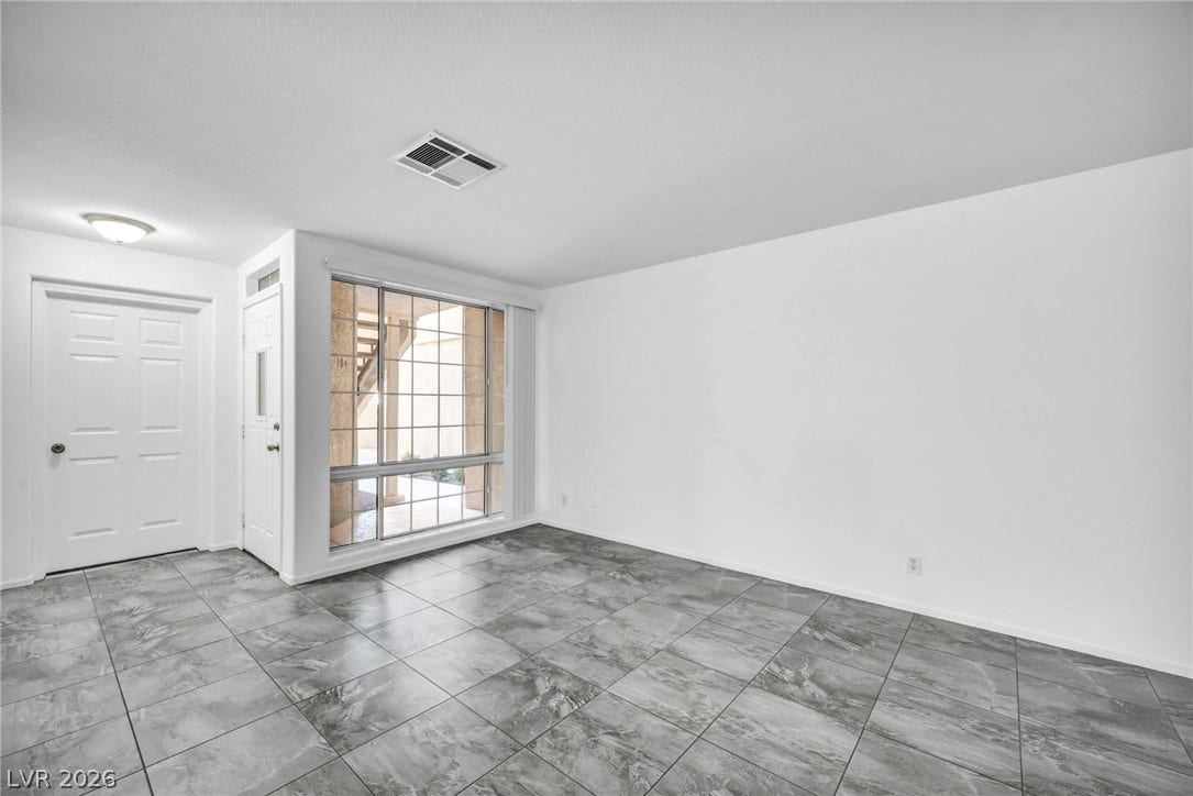 3613 Shawn Reynolds Court, #104, Las Vegas, NV 89129 Large tiles run throughout the versatile living area featuring a large window and entry doors.