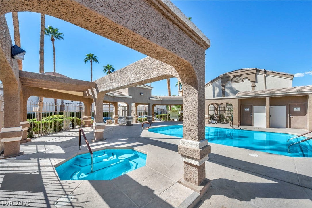 3613 Shawn Reynolds Court, #104, Las Vegas, NV 89129 A sparkling swimming pool and adjacent spa sit under a clear blue desert sky.