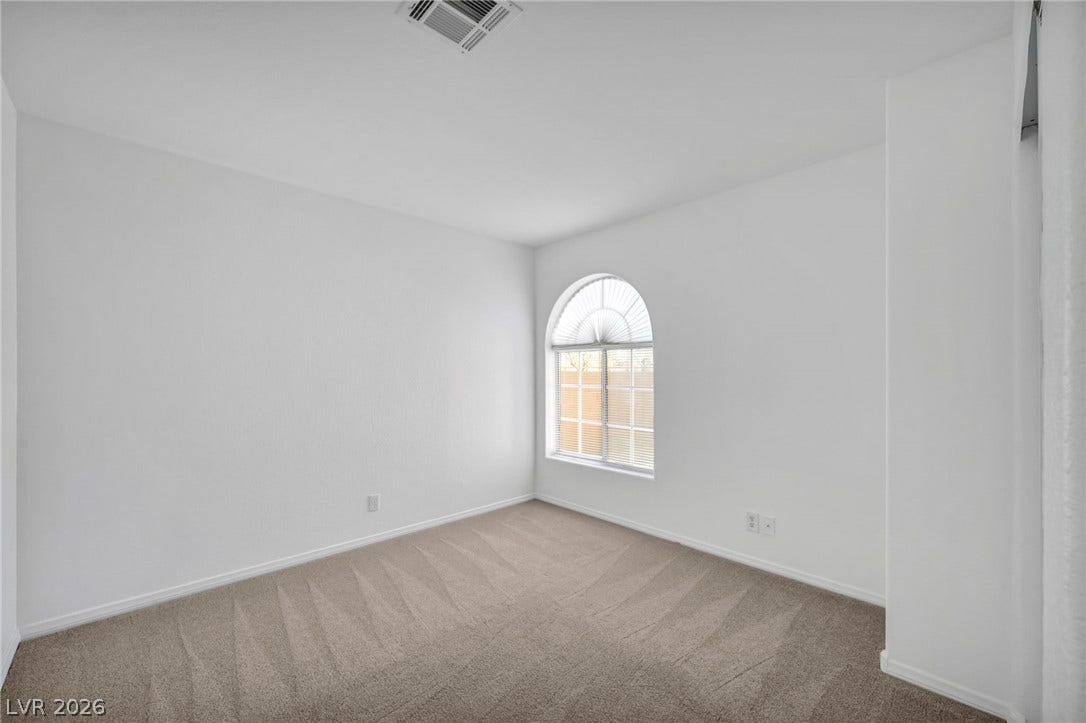 3613 Shawn Reynolds Court, #104, Las Vegas, NV 89129 Bedroom 2 - An arched window floods this carpeted bedroom with natural light.