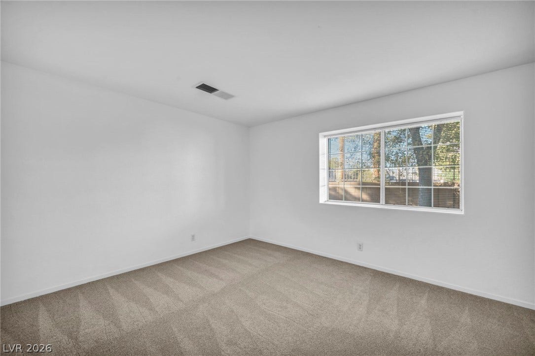 3613 Shawn Reynolds Court, #104, Las Vegas, NV 89129 Plush carpeting and a wide window with integrated blinds define this versatile bedroom.