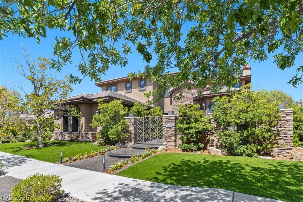2985 American River Lane, Las Vegas, NV 89135 Stone and stucco facade with elegant entry and mature landscaping.