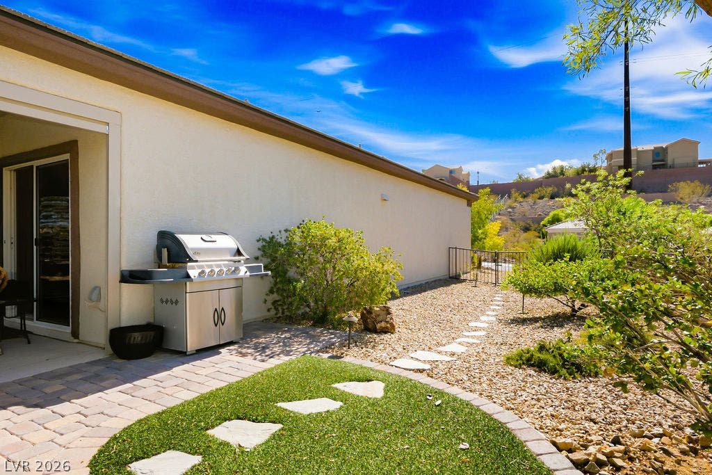 2510 Hamonah Drive, Henderson, NV 89044 An inviting backyard features a stone paver patio and a winding flagstone pathway.