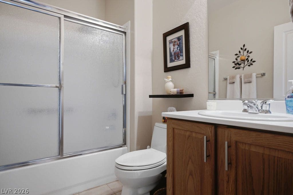 2510 Hamonah Drive, Henderson, NV 89044 Functional bathroom design incorporates a wood vanity and a glass-enclosed tub shower.