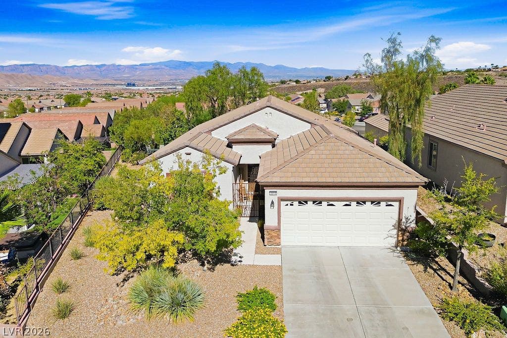 2510 Hamonah Drive, Henderson, NV 89044 An inviting exterior features a concrete driveway, tile roof, and sweeping mountain views.