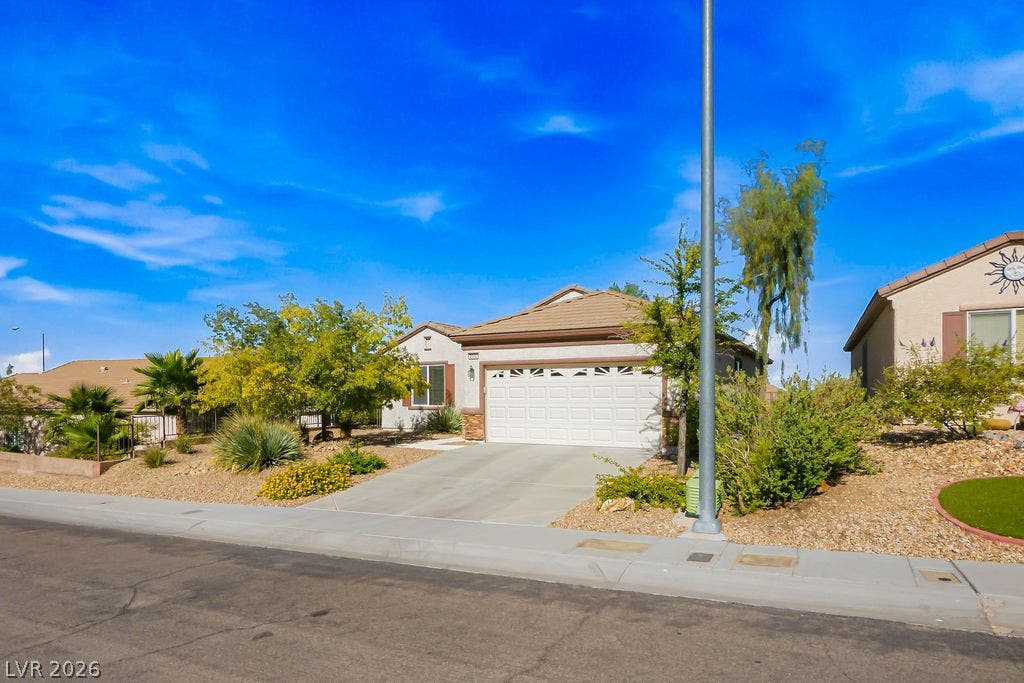 2510 Hamonah Drive, Henderson, NV 89044 Neat desert landscaping and a paved driveway lead to this classic tile-roof residence.