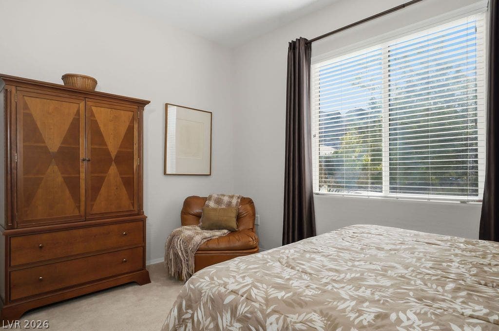 2510 Hamonah Drive, Henderson, NV 89044 Soft carpeting underfoot and a large window framing leafy views define this peaceful bedroom.